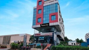 A multi-story building with a modern design, featuring a prominent 'Suncity' sign.