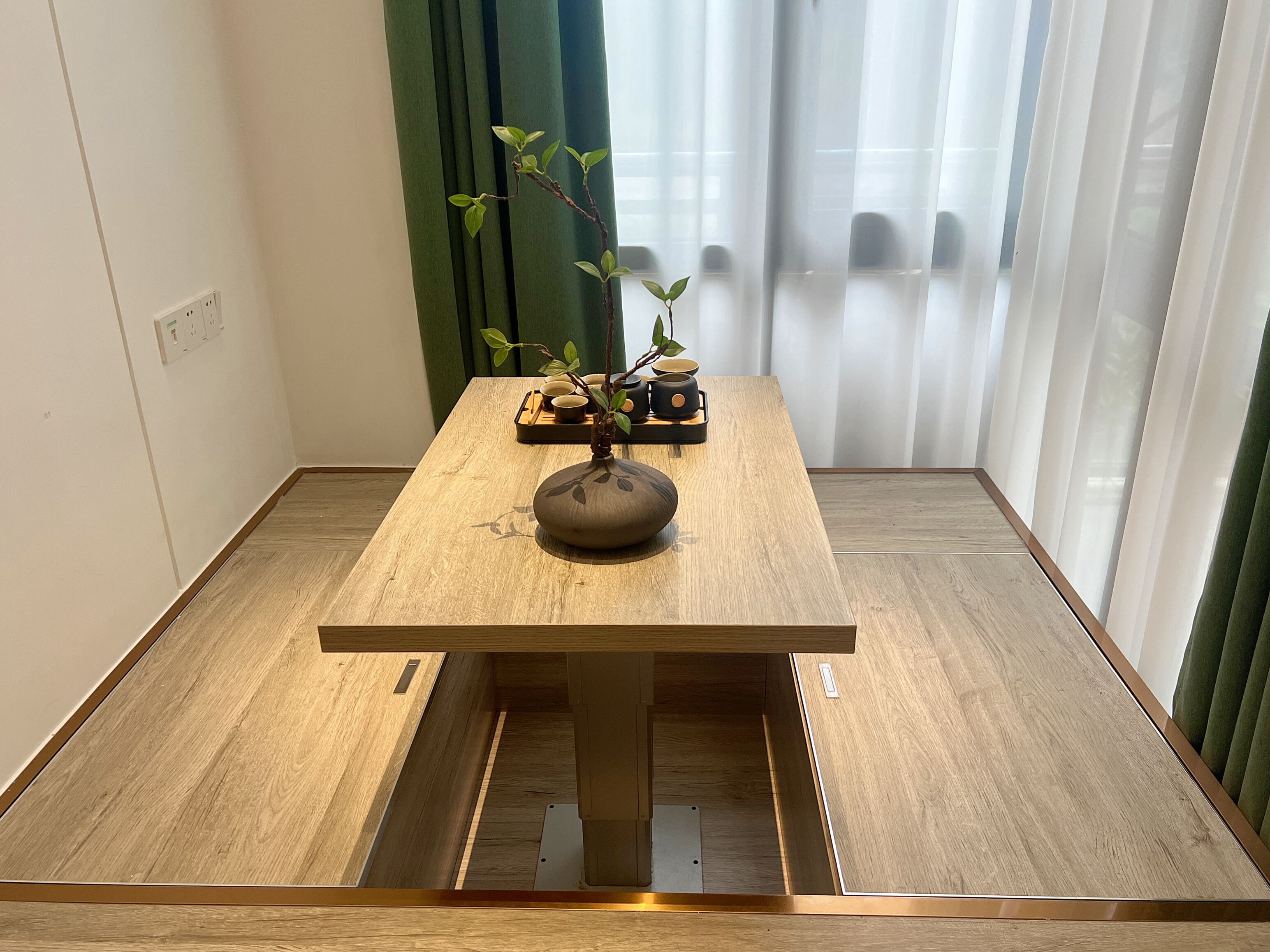 Una mesa de madera con un florero y una planta.