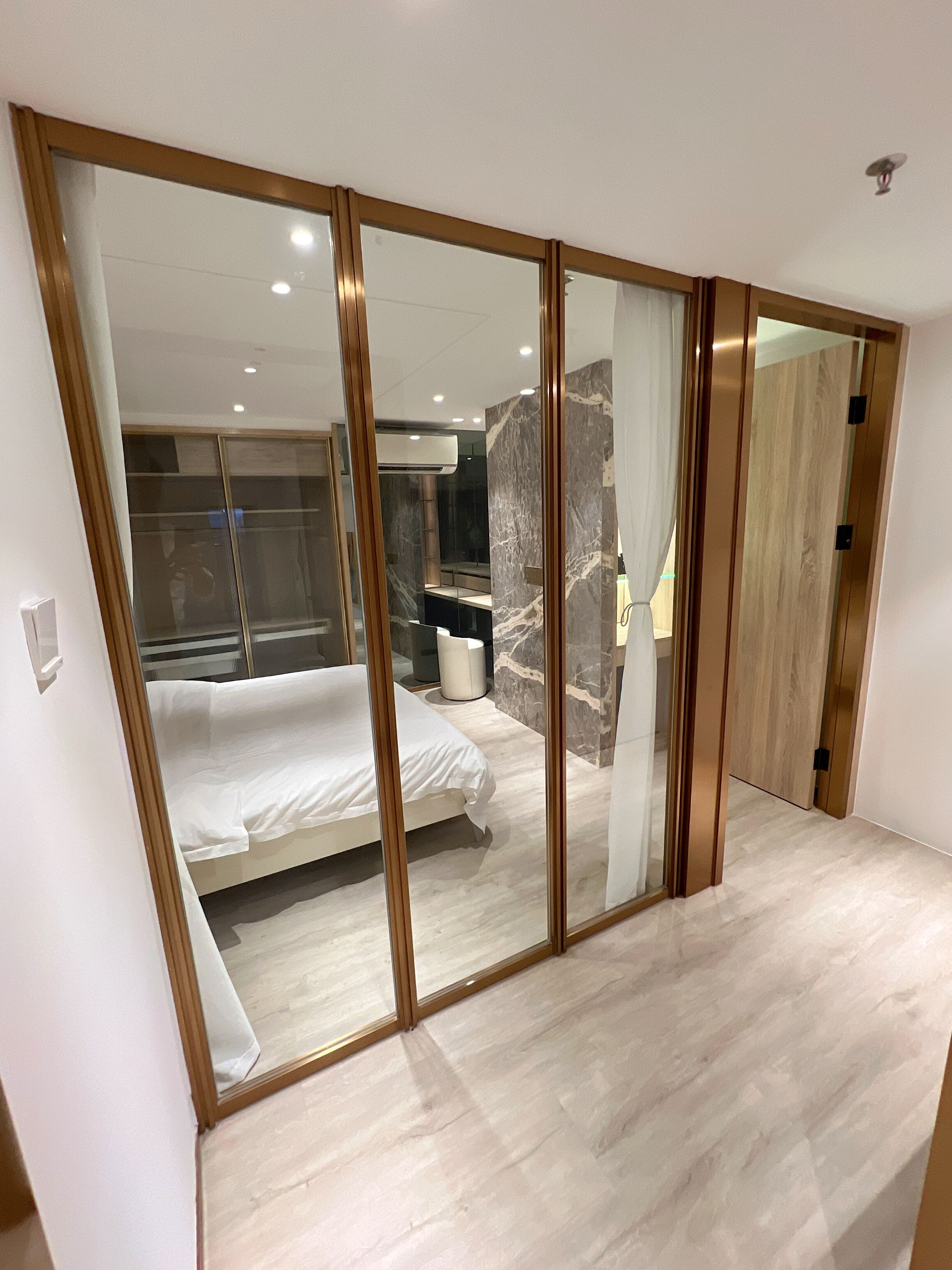 A bedroom with a bed, a wardrobe, and a bathroom.