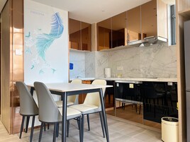Una cocina moderna con encimera de mármol, horno empotrado y comedor con mesa y sillas.