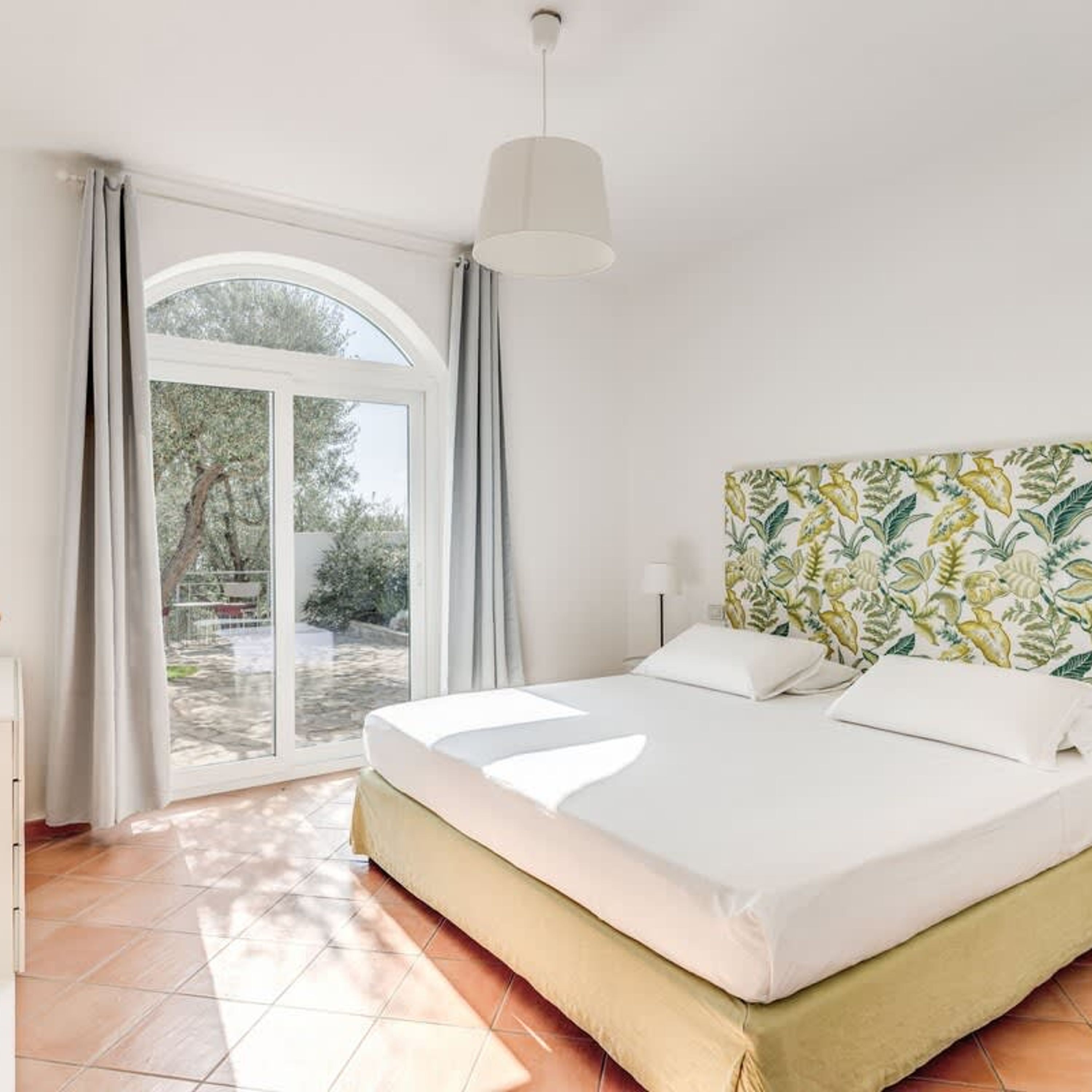 Quarto com cama, janela e vista para o exterior.