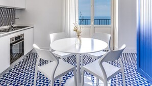 A modern kitchen with white cabinets, a built-in oven, and a black and white patterned backsplash. - Le Arcate Giuliana in Massa Lubrense (Massa Lubrense)
