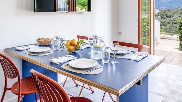 A dining area with a table set for two, a bowl of fruit, and a pitcher of water. - M3 - Magma in Sant Agata sui Due Golfi (Massa Lubrense)