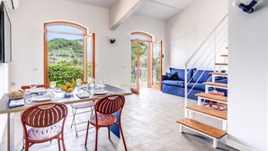 A modern kitchen with a dining area, large windows, and a staircase leading to a living area. - M3 - Magma in Sant Agata sui Due Golfi (Massa Lubrense)