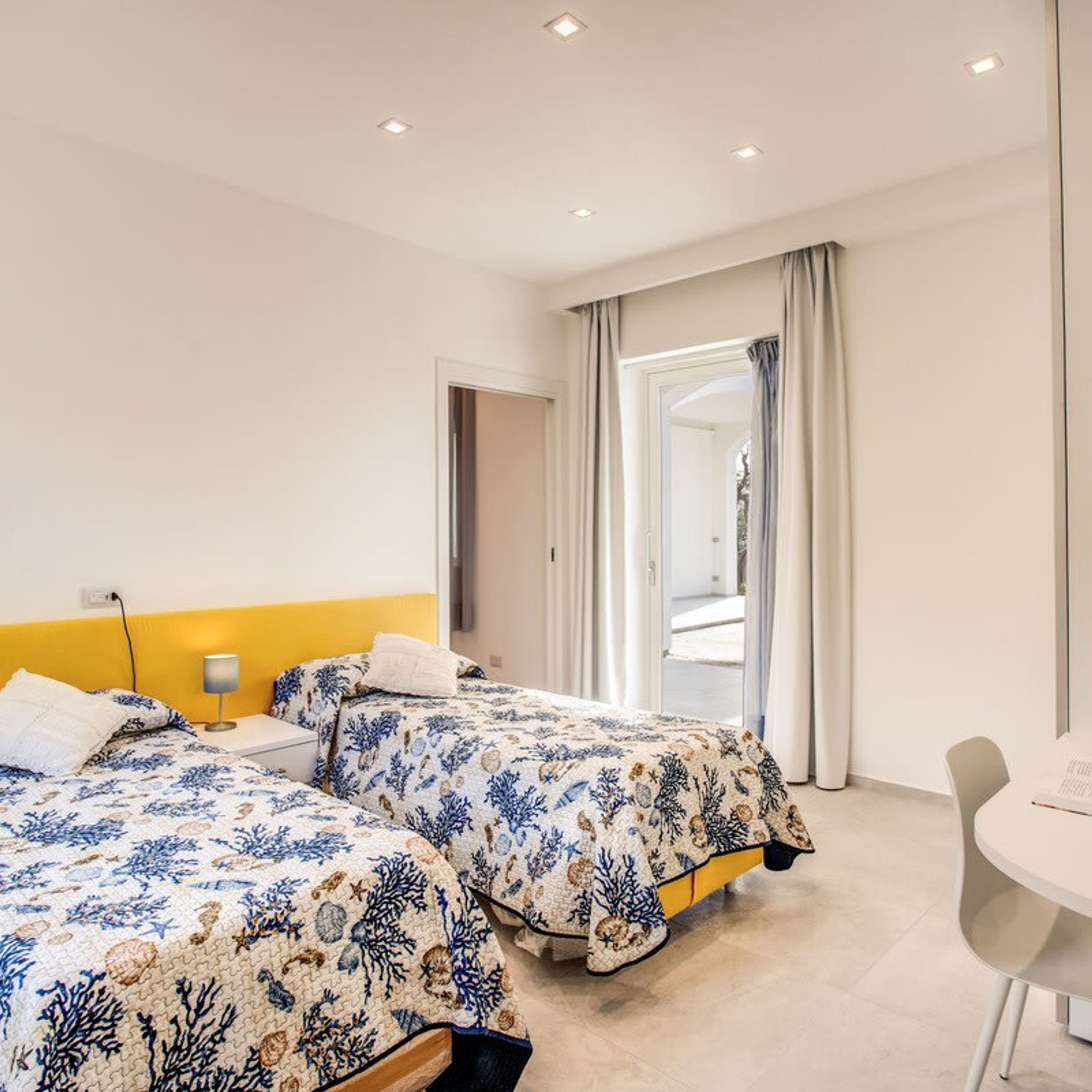 Een hotelkamer met twee bedden, een tafeltje en een stoel.