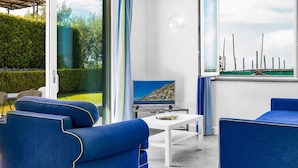 Een moderne woonkamer met een televisie, een salontafel en blauwe banken.