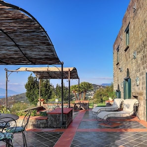 A patio with outdoor furniture, a pergola, and a view of the countryside. - Fondo Turiello in Massa Lubrense (Massa Lubrense)