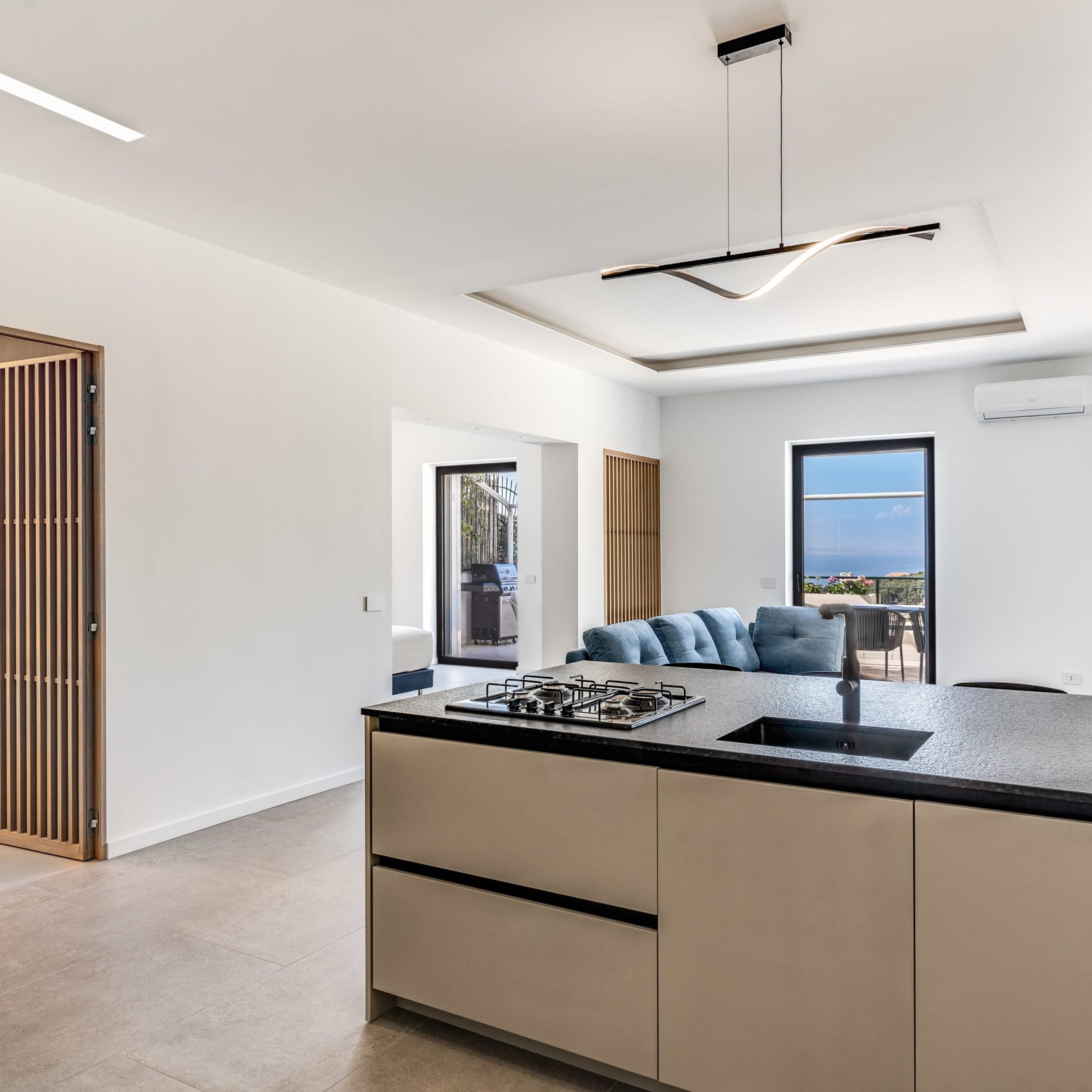 A modern kitchen with a central island, built-in appliances, and a view to the outdoors.