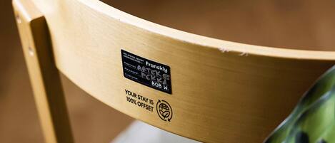 Una silla de madera con una etiqueta que indica que es un diseño 'Frangly' de 'Bob W.' y 'After 6', con el texto '100% Offset'.