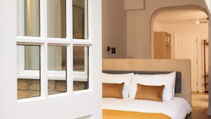 Een slaapkamer met een bed, hoofdeinde en een deur met ramen.