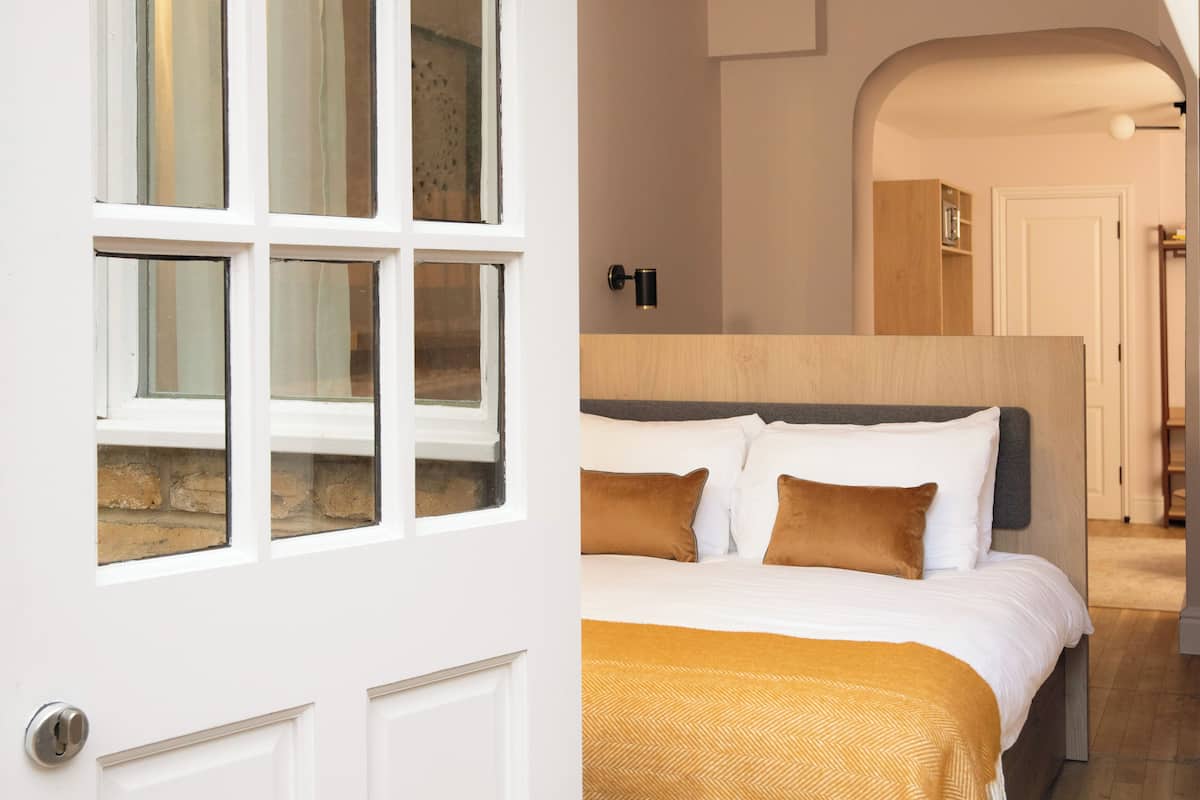 Een slaapkamer met een bed, hoofdeinde en een deur met ramen.