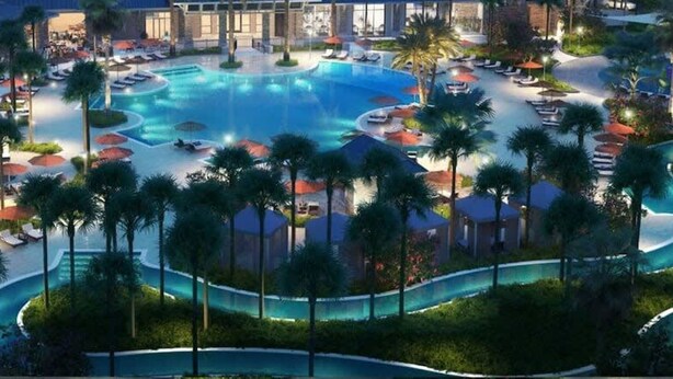 A resort with a large swimming pool, palm trees, and a view of the city at dusk. - 1807 Amazing 5BR Brand New House (Davenport)