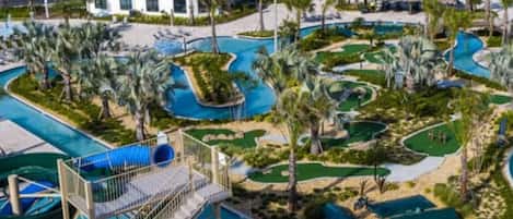 Un resort con piscina, tobogán de agua y campo de golf.