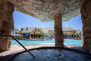 A hot tub with a view of a pool and a building with a tiled roof. - 8950 Amazing 5BD Home With Pool (Kissimmee)