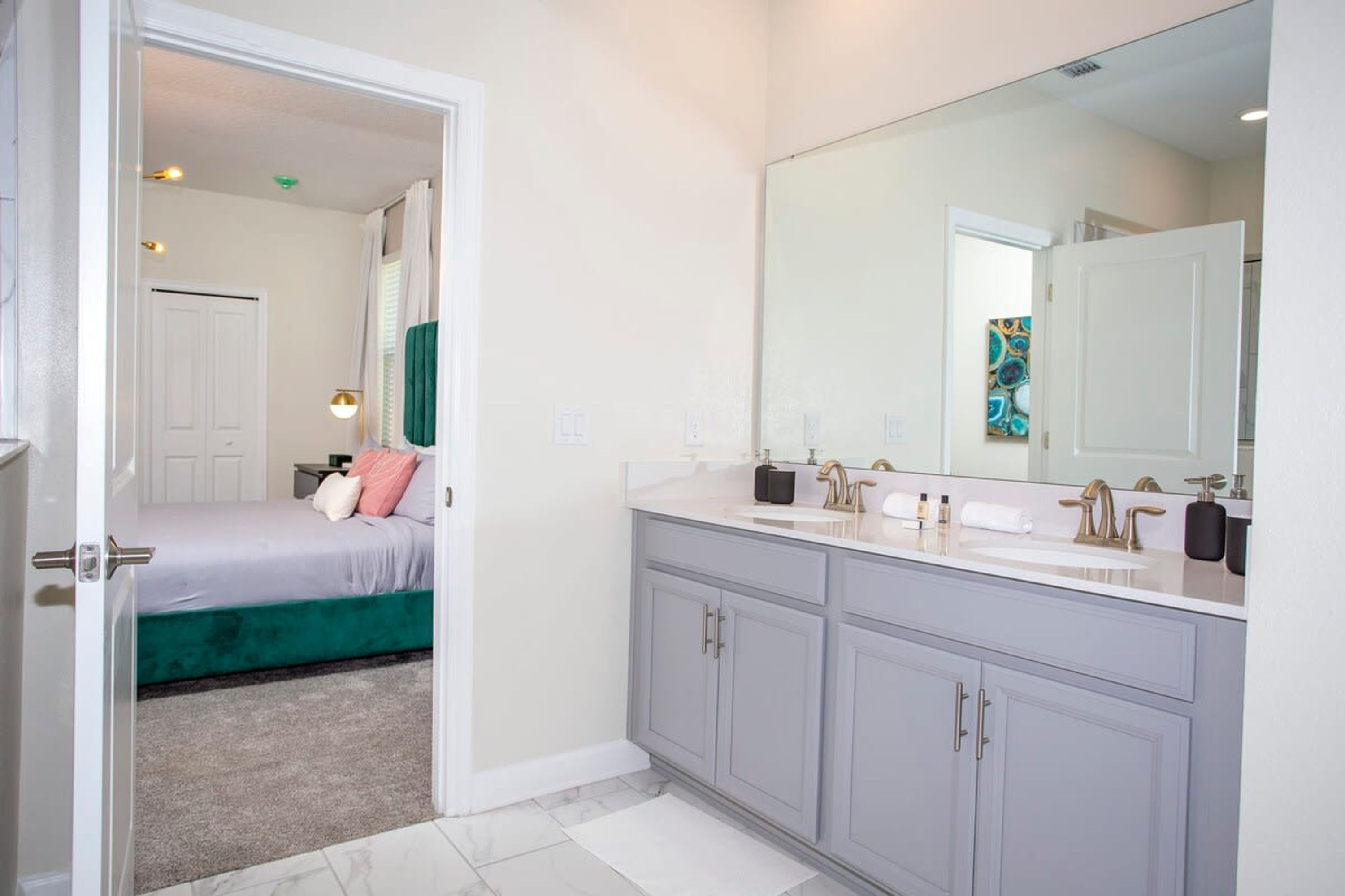 Une salle de bain moderne avec un grand miroir, deux lavabos et une douche à l’italienne.