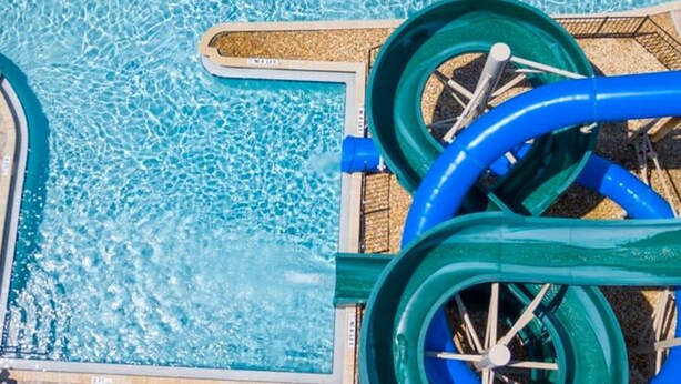 Una piscina con dos toboganes acuáticos grandes.