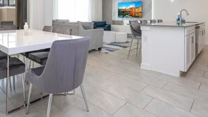 Un apartamento moderno con comedor, sala de estar y cocina.