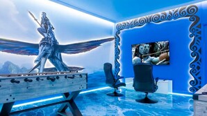 Ein Zimmer mit einem großen Bildschirm, einer Statue und einem Pool.