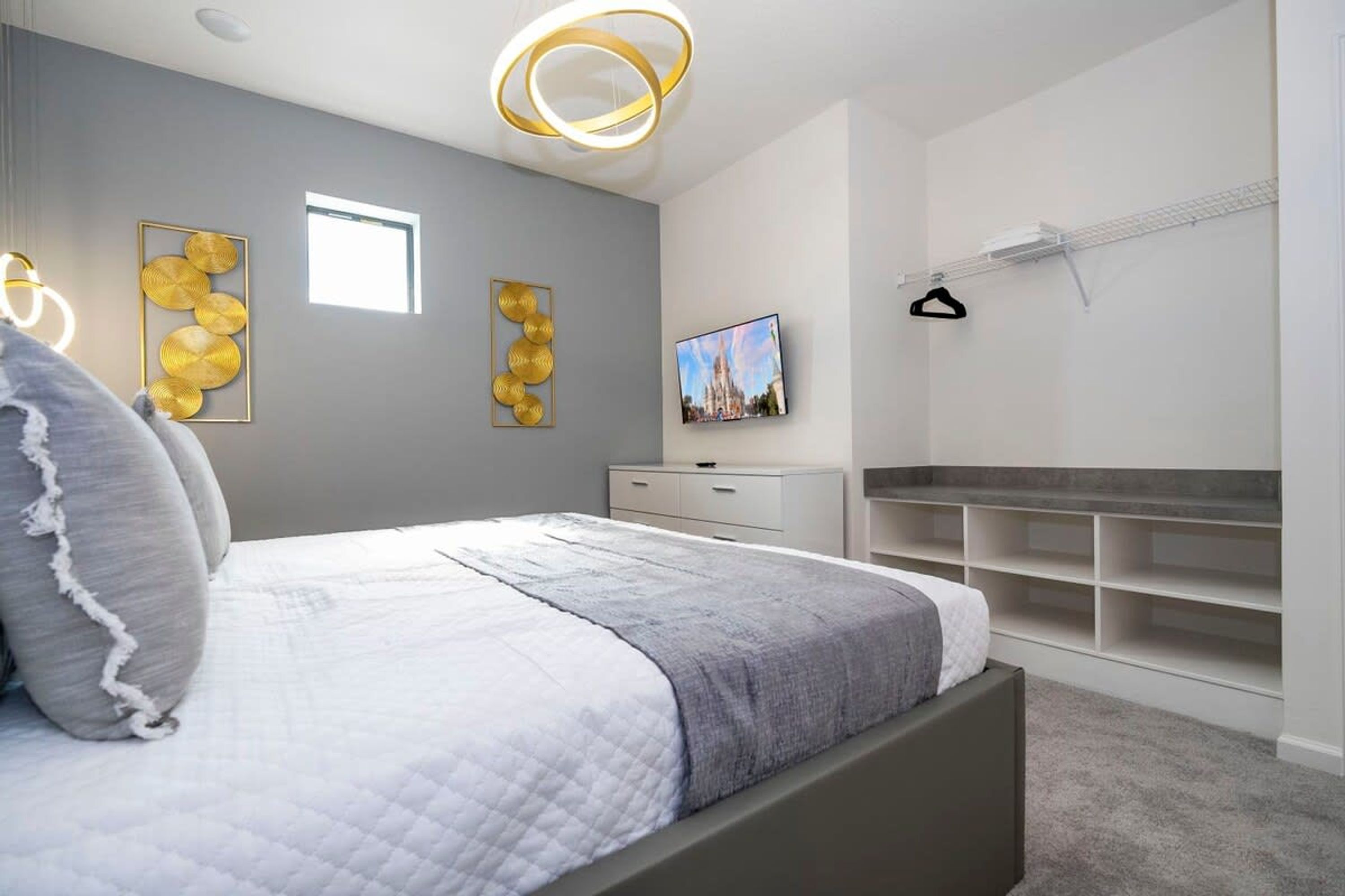 Ein modernes Schlafzimmer mit Bett, Fernseher und Einbauschränken.