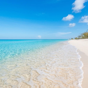 Una playa con agua turquesa cristalina y arena blanca.