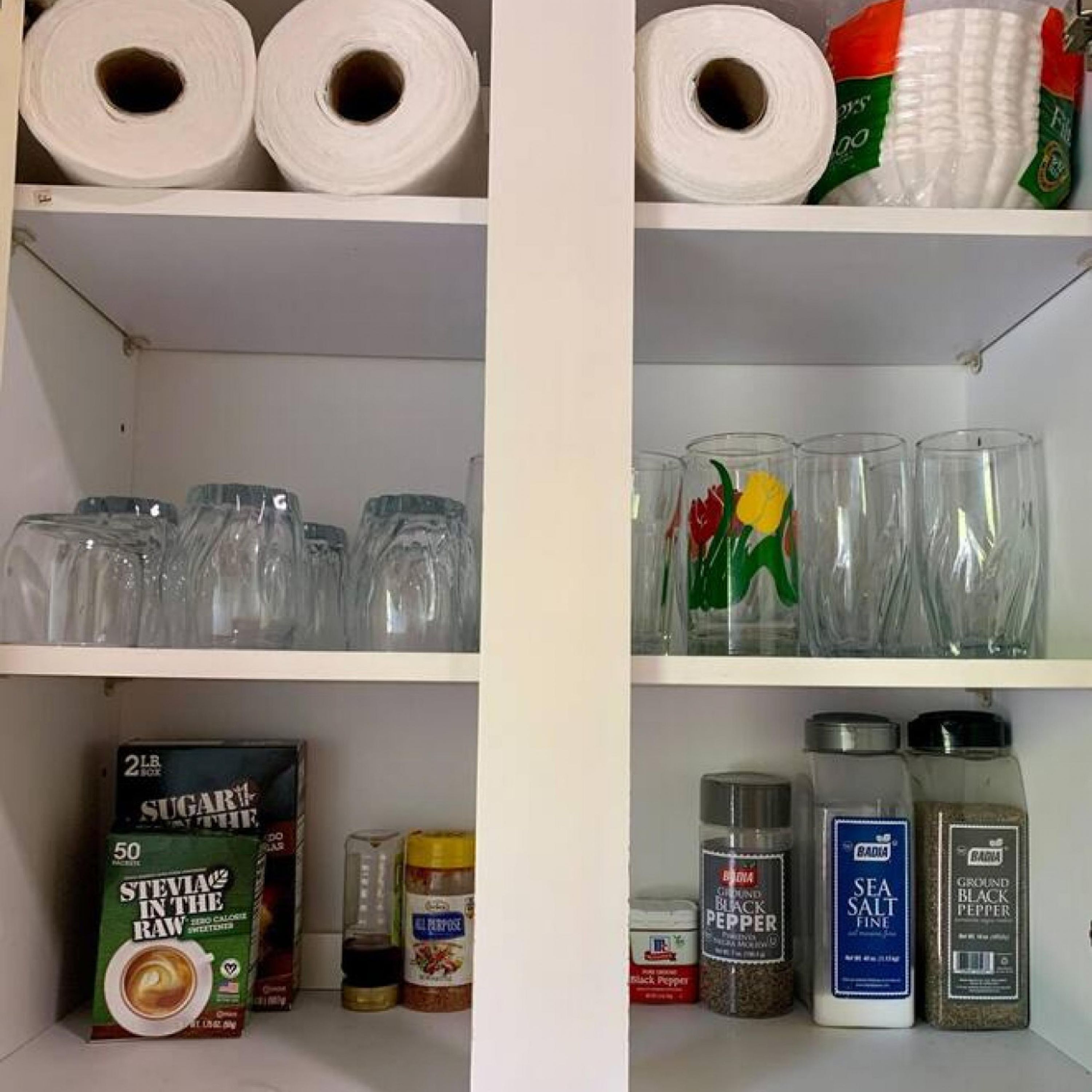 Ein Regal mit Toilettenpapier, Gläsern und Küchenkräutern.