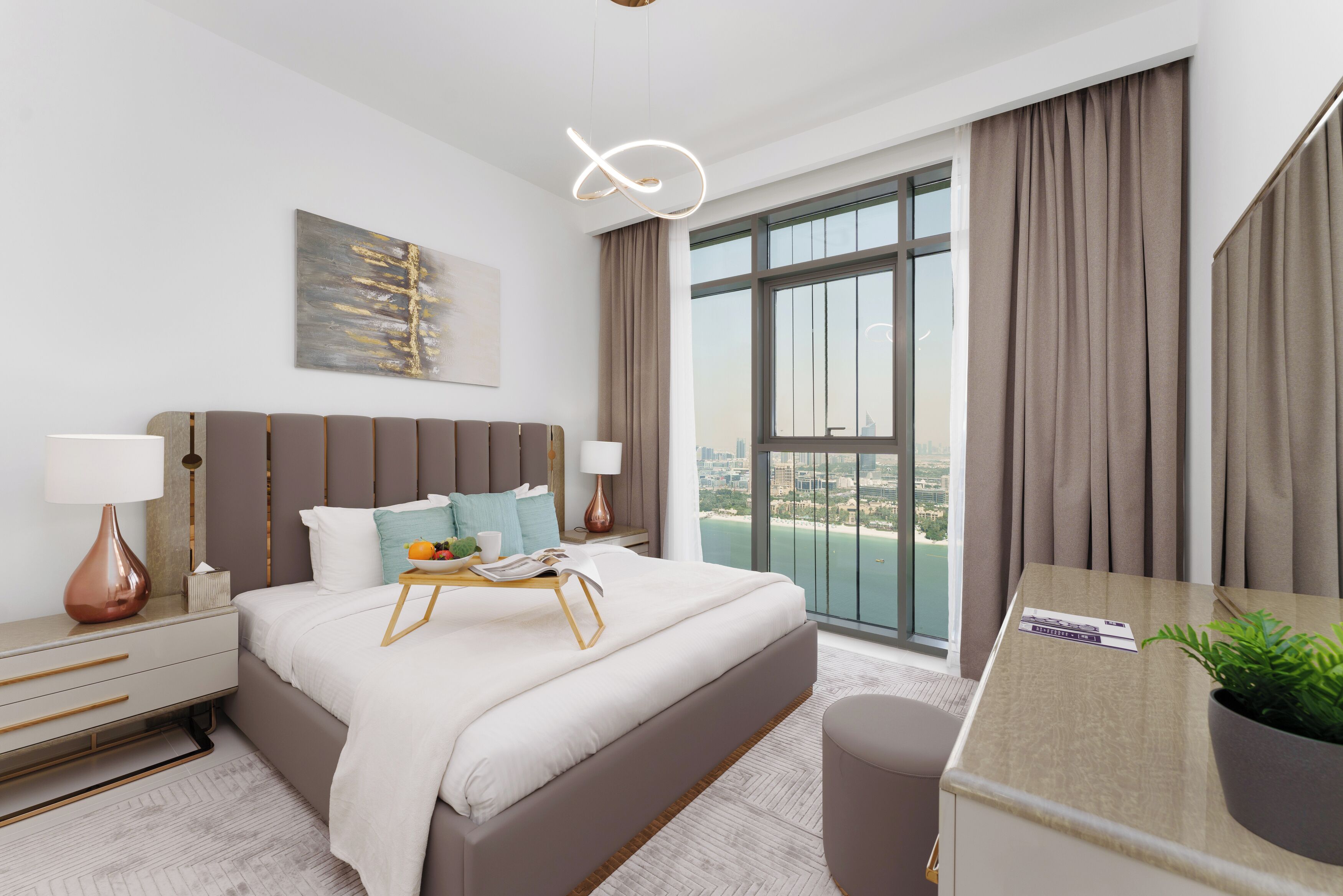 A modern hotel room with a large bed, a desk, and a view of the city.