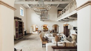 A spacious interior with a high ceiling, a chandelier, and a dining area in the background. - Le Porciglia by Boutique (Colle di Val d'Elsa)