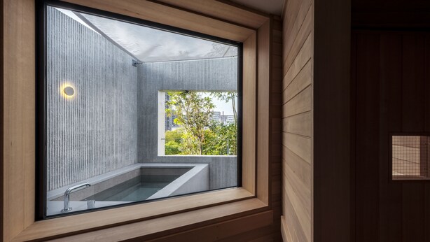 Ein modernes Badezimmer mit großem Fenster, einer eingebauten Badewanne und einer Holzwand.