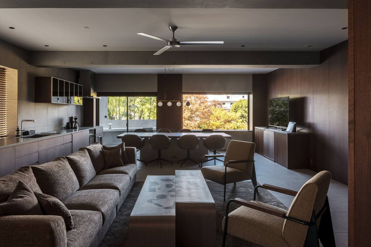 Un salon moderne avec un canapé, des fauteuils, une table basse et un téléviseur.