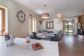 Enjoy meals for two at a spacious dining table, accompanied by a wine glass and fresh fruit.