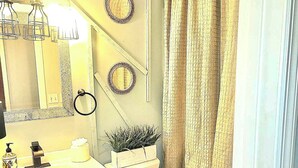 Une salle de bain équipée de toilettes, d’un lavabo, d’un miroir et de décorations murales.