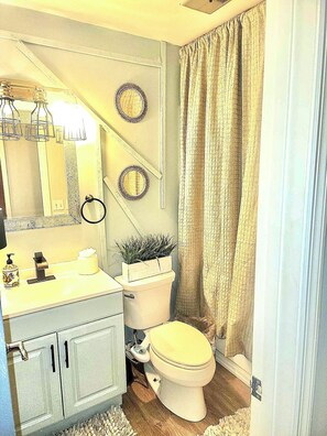 Un bagno con WC, lavandino, specchio e decorazioni a parete.