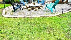 Un espace patio avec une table ronde, des chaises et une petite fontaine.