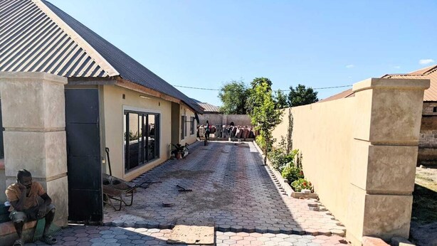 A paved walkway leading to a building with a tiled roof and a concrete pillar. - This 4 bed 3 full bath a big living room, nice kitchen located in Chililabombwe  (Chililabombwe)