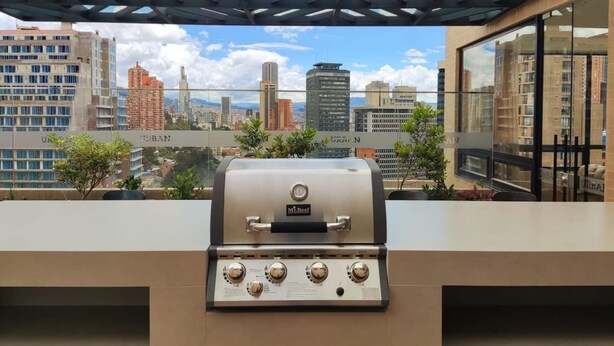 Eine Dachterrasse mit Grill, Blick auf die Stadt und modernem architektonischen Design.