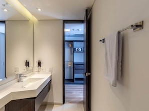 A modern bathroom with a large mirror, two sinks, and a towel rack. - Homey Loft in San Patricio (Bogotá)