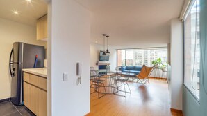 A modern apartment with a kitchen, dining area, and living room.
