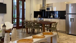 Une cuisine moderne avec un coin repas, comprenant une table en bois, des chaises et un banc intégré.