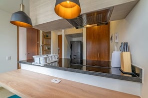 A modern kitchen with a granite countertop, stainless steel appliances, and wooden cabinets.
