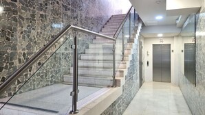 A modern interior with a marble staircase, metal handrails, and a clean, tiled floor. - Modern 2BR In La Cresta (Panama City)