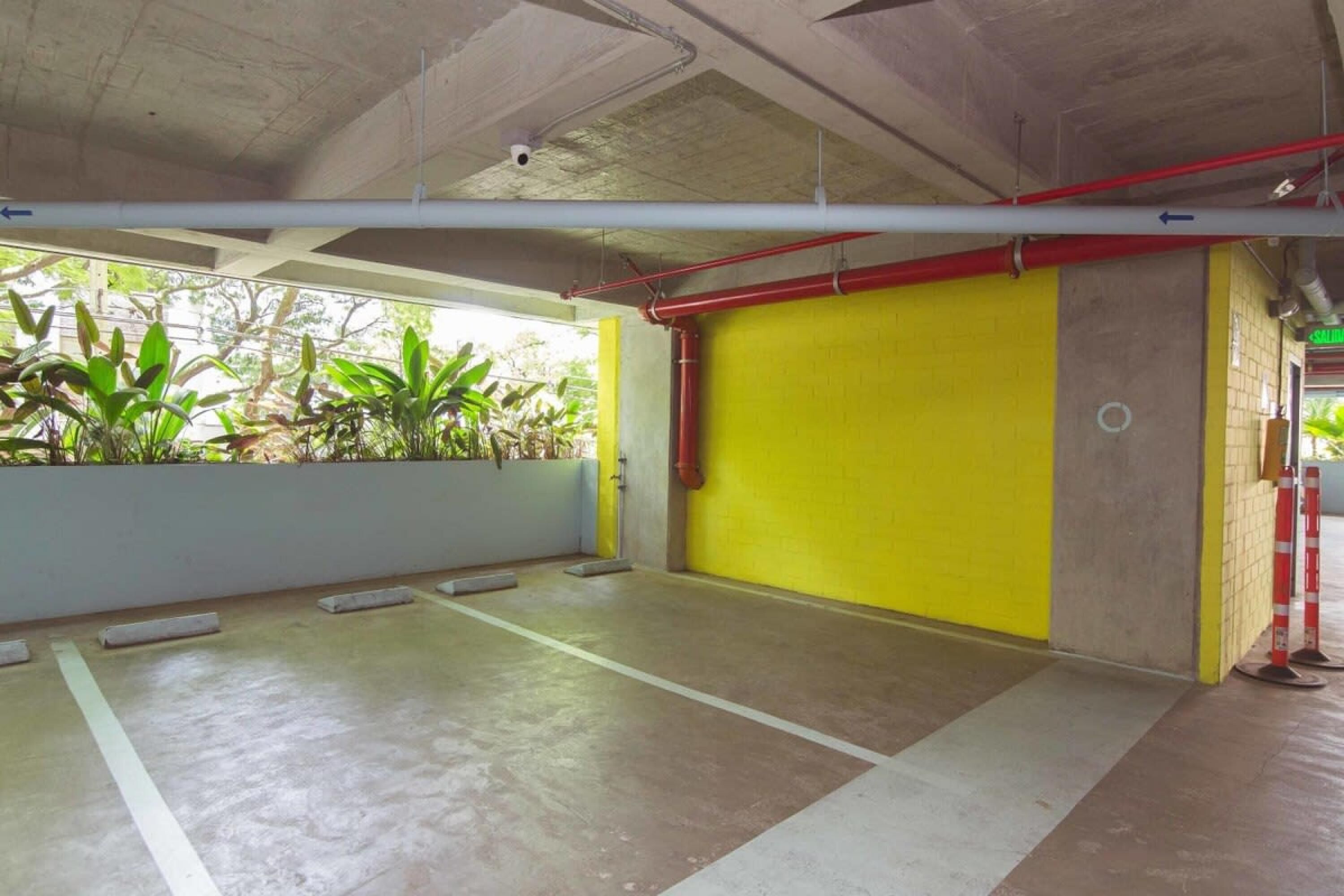 Um espaço de estacionamento interno com piso de concreto e paredes amarelas.