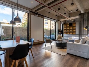 Un intérieur moderne comprenant un coin repas, des sièges et un espace de vie avec un canapé et un téléviseur.
