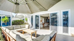 An outdoor seating area with a sofa, a table, and an umbrella. - 6 Beach Rd Goolwa South (Goolwa South)