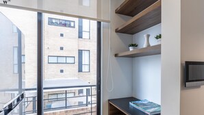 A modern interior with a large window, a wooden shelf with a magazine, and a small potted plant. - w Splendid Loft in Santa Ana (Bogotá)