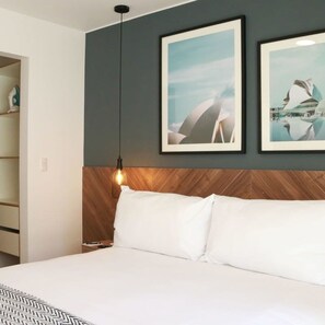 A hotel room with a bed, a wooden headboard, and two framed pictures on the wall. - w Dreamy 1BR in Barranco (Lima)