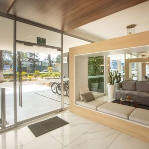 A modern reception area with a sofa, a coffee table, and a potted plant. - w Artistic 1BR in Barranco (Lima)