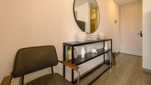 A hallway with a black console table, a mirror, and a chair. - Cozy Loft in Country (Bogotá)