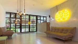 A modern interior with a sofa, a glass door leading outside, and a neon light on the wall. - Trendy Loft With Balcony in Laureles (Medellín)