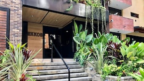 Un escalier menant à l’entrée d’un bâtiment, avec une enseigne indiquant « EKMOS ».