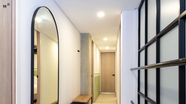 A hallway with a bench, a mirror, and a door. - w Beautiful 3BR w/ AC in Laureles (Medellín)